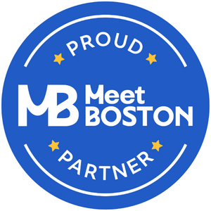A blue circle with white outlining and white font in the center that says Proud MB Meet Boston Partner