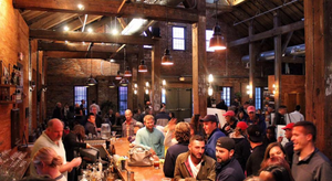 Image is of the cocktail lounge bar at Boston Harbor Distillery with patrons surrounding