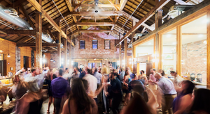 Image is of the main room at Boston Harbor Distillery full of people