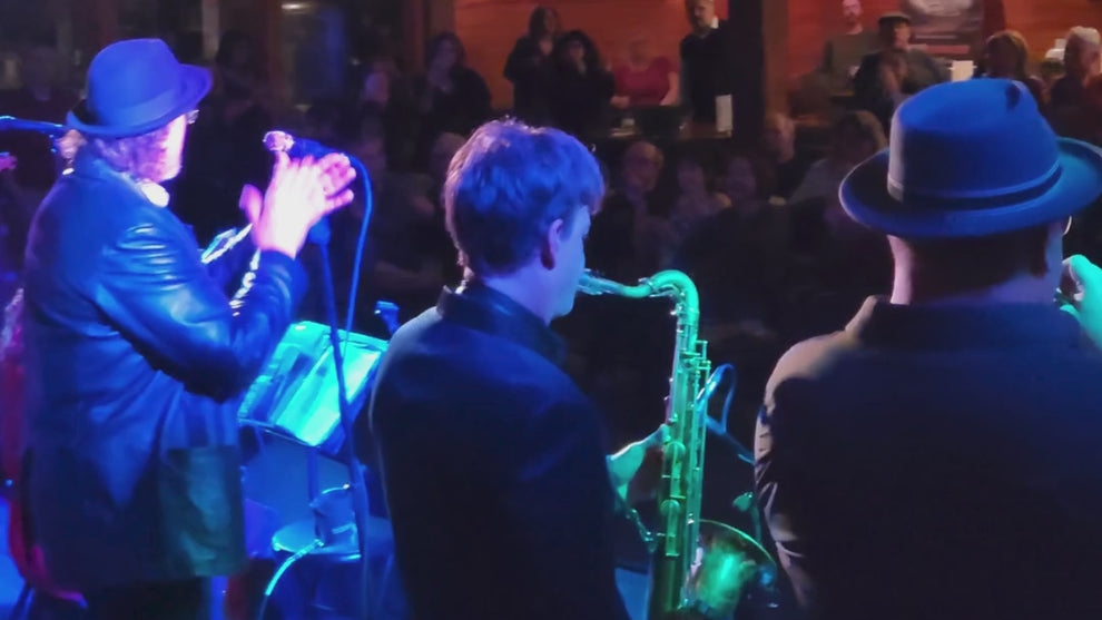 A video shot from behind a band playing live music to a crowd of people at Boston Harbor Distillery.